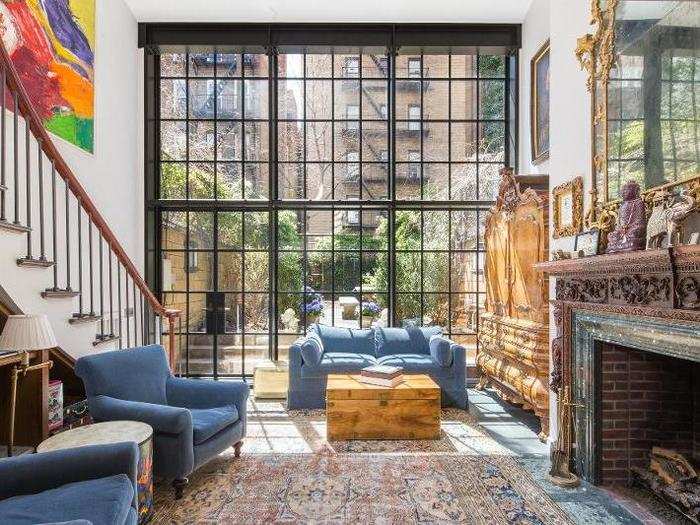 An 18-foot window wall floods the double-height living room with light from the private garden out back. The gas fireplace has an 18th-century mantle.