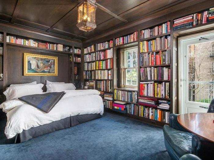 The master bedroom, lined with built-in dark wood bookshelves, looks like a cozy place to curl up with one of the tomes on the wall.