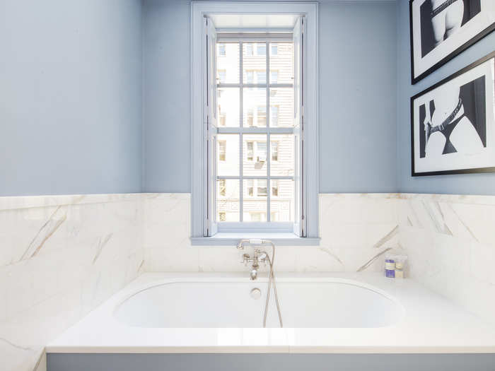 Bathrooms are marble-lined; this one has a sunken tub and Waterworks fixtures.