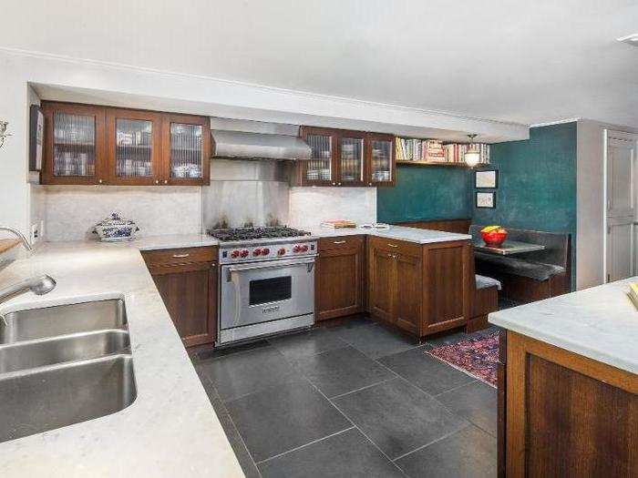 The spacious kitchen has oak cabinetry, marble counters, and high-end appliances.