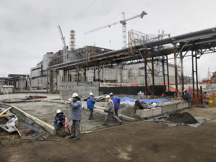 Construction workers are building a structure to cover the damage.