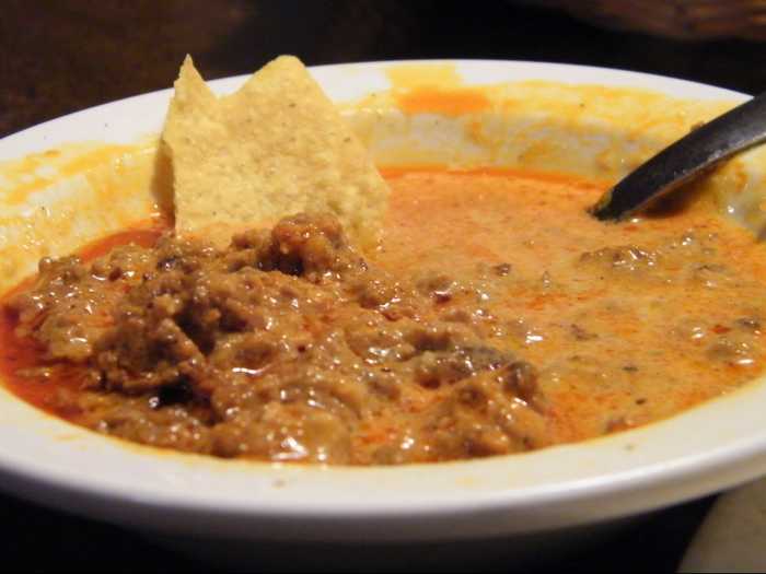 Queso flameado, Spanish for "flamed cheese," is a dish of hot melted cheese topped with a spicy chorizo meat sauce. The dish is said to have originated around the campfires at the Mexico-United States border.