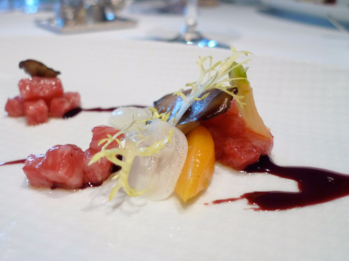 Plates like this beef tartare — which is accompanied by carrots, Tokyo turnips, hen-of-the-woods mushroom, pickled garlic, frisée, and a red wine reduction — are light, yet full of flavor.