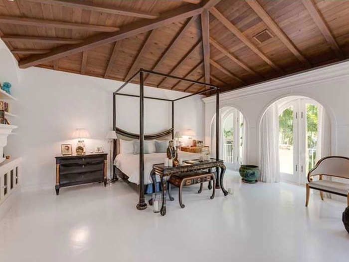 The master bedroom has a clean design with an impressive ceiling.