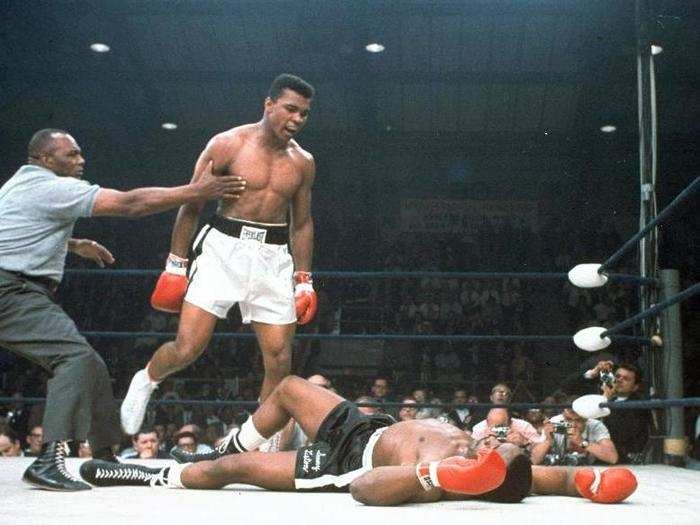 A referee holds back Muhammad Ali after he knocked out challenger Sonny Liston in the first round of their title fight in Lewiston, Maine, May 25, 1965