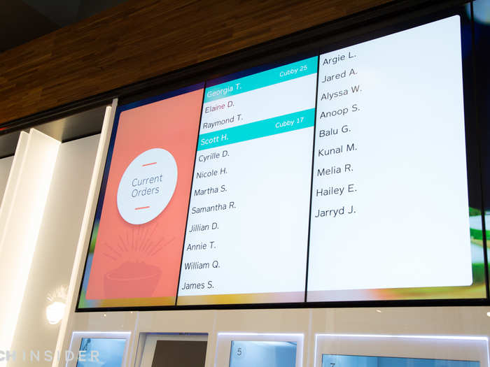 A screen overhead broadcasts whose orders have arrived. The number next to your name corresponds with the cubby where your food is.