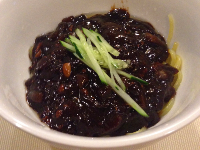 Jajangmyeon noodles are topped with Chinese black soybean sauce, diced pork, and vegetables.