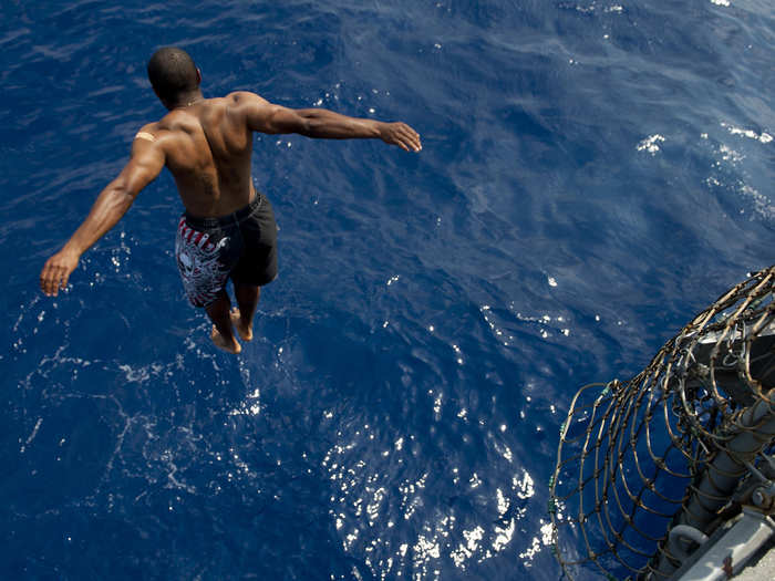 A sailor jumps from the USS Jason Dunham into the Mediterranean Sea.