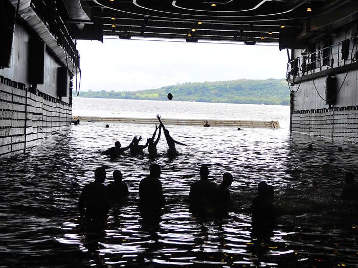 Sailors play football in the well deck of the USS Cleveland off of the coast of Espiritu Santo, Vanuatu.