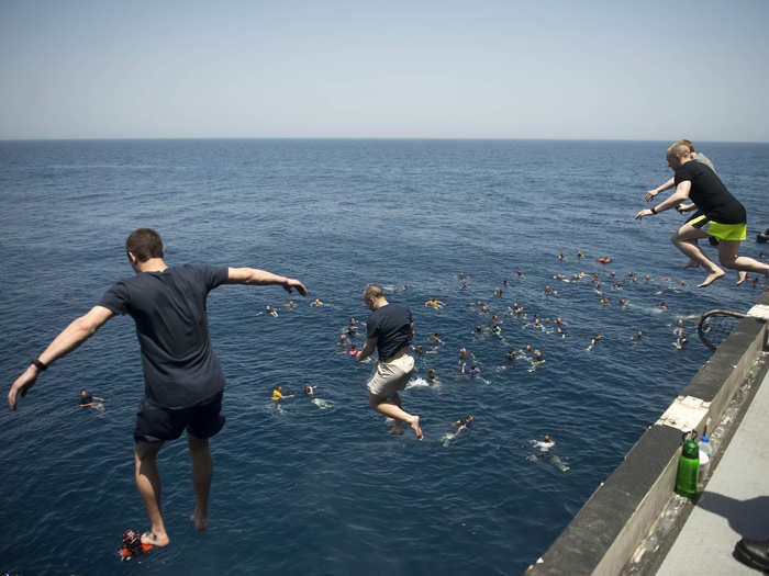 Sailors jump from the aircraft carrier USS Dwight D. Eisenhower in the North Arabian Sea.