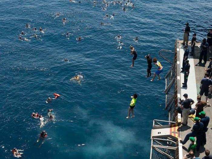 Sailors from the aircraft carrier USS Dwight D. Eisenhower jump into the North Arabian Sea.