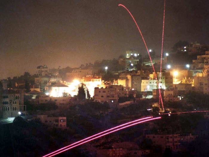 Tracer bullets that are fired by Israeli soldiers in the outskirts of Jerusalem, hit and ricochet off a building in an Arab village, outside Bethlehem in the West Bank on November 1, 2000.