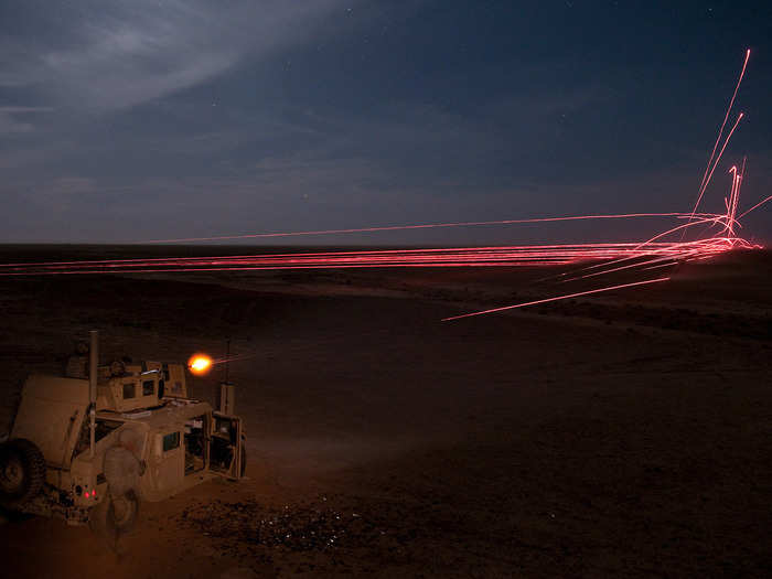 Soldiers fire .50-caliber machine gun rounds at the base of a training target to indicate to nearby helicopters where to fire their rockets during partnered aerial-ground integration training between US and Iraqi forces.