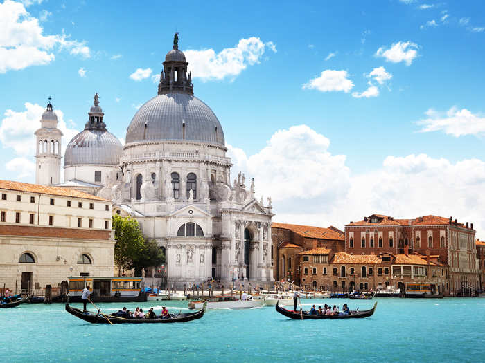 8. Venice, Italy — Squeeze your friends onto a gondola and take it in turns to steer your way under old bridges and past gorgeous buildings like St. Mark