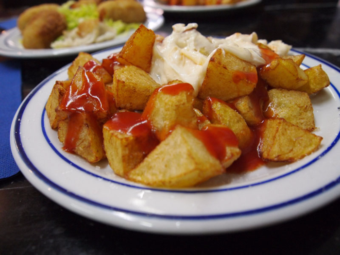 12. Patatas bravas — "A Spanish dish of sautéed potatoes in or with a spicy tomato sauce, frequently served as a tapa."