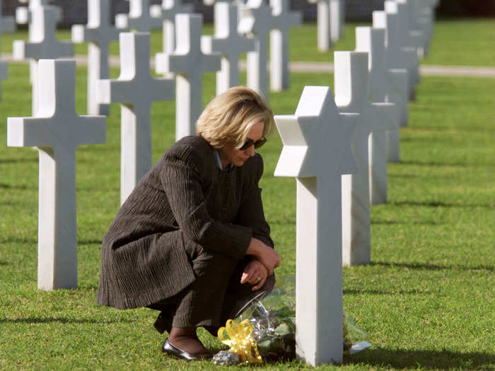 Hillary kneels before the grave of US Private Celia Goldberg, who was killed in Tunisia during World War II, at the North Africa American Cemetery, outside Tunis, in 1999.