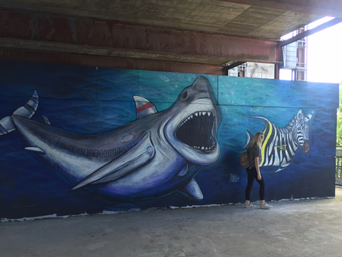 Lower down in the complex, a shark approaches a zebra fish with its mouth wide open.