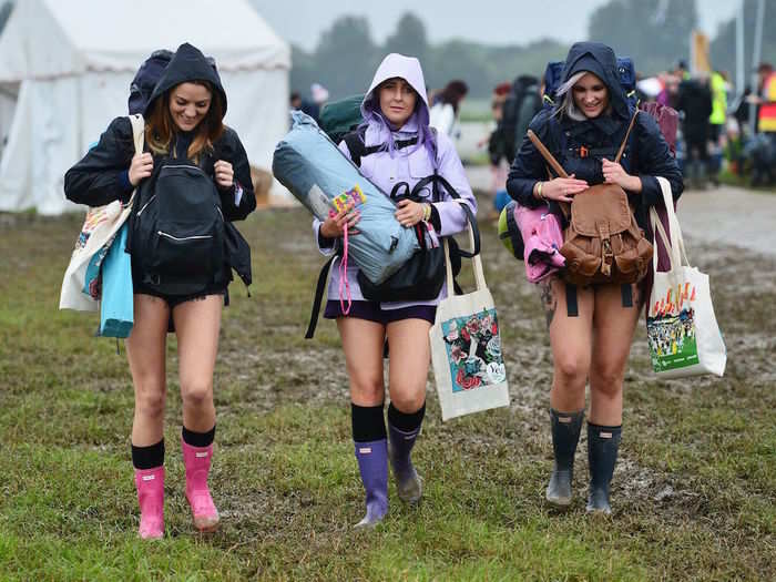 These festival-goers came prepared wearing wellington boots and their hoods up.