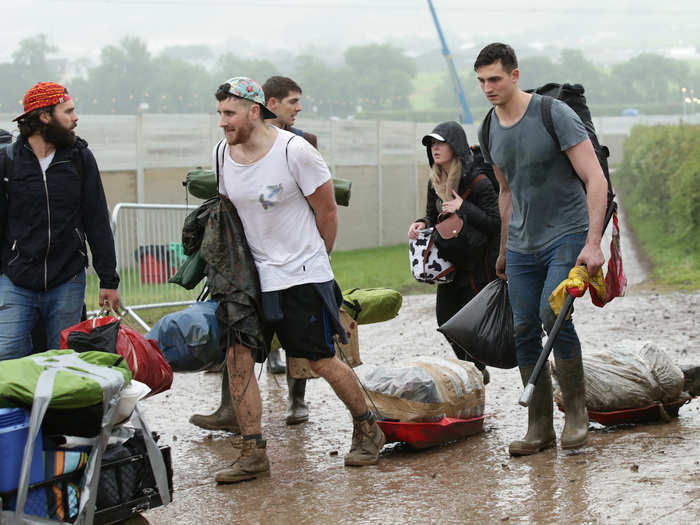 These festival-goers have resorted to wheeling their wrapped-up belongings right through the soggy fields.