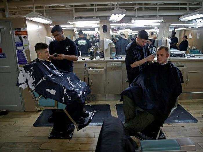 US Navy sailors gets a hair cut at the barber shop on board of the USS Harry S. Truman aircraft carrier in the eastern Mediterranean Sea, June 14, 2016.