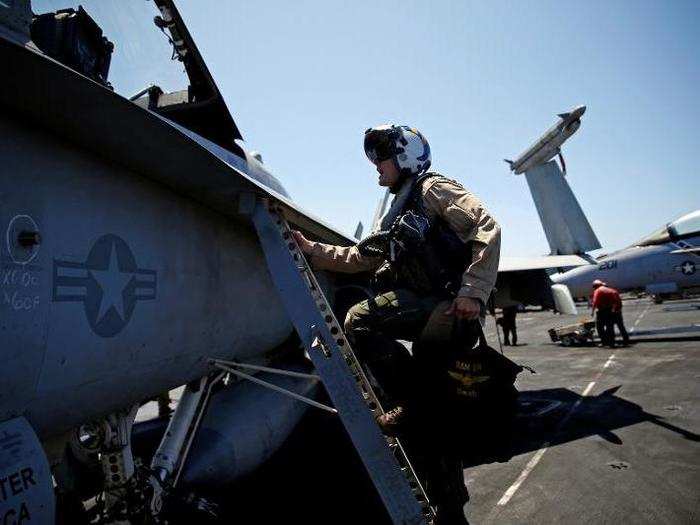 Navy F/A-18 pilot Commander Higgins from the VFA-83 Squadron also known as the "Rampagers" climbs in to his plane before a mission, on the USS Harry S. Truman aircraft carrier, in the eastern Mediterranean Sea, June 15, 2016.