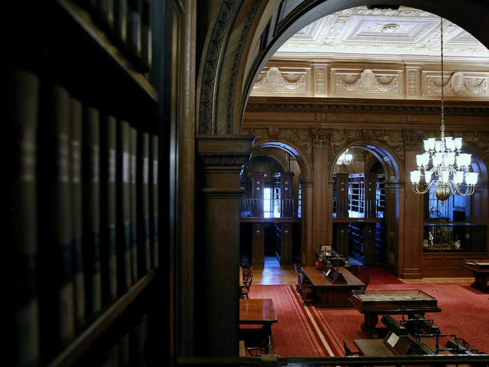 Carved oak walls and arches are seen in the reading area of the library.