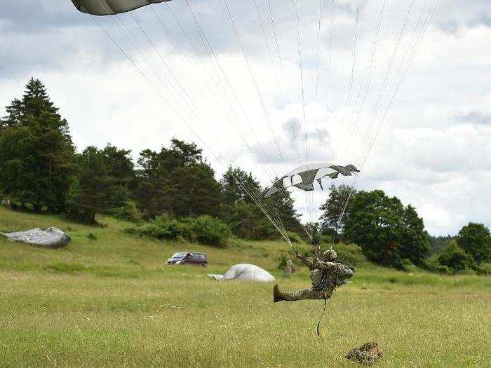 A US paratrooper with the 82nd Airborne Division lands with his parachute.