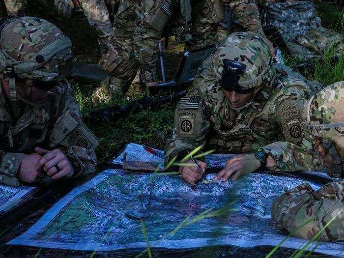 US soldiers locate a target on a map.