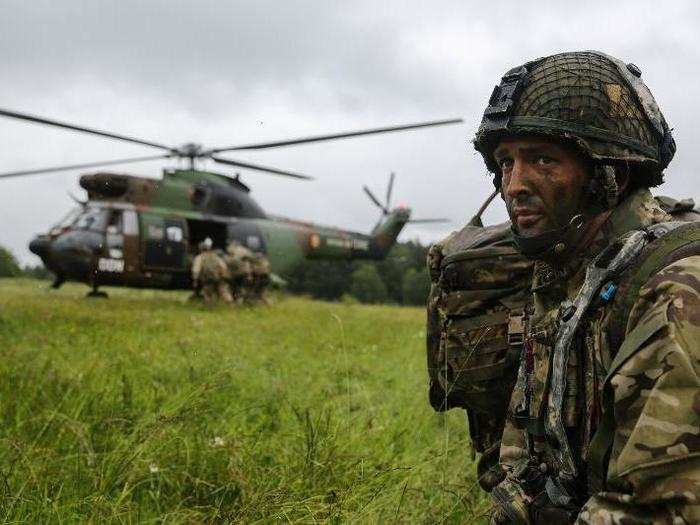 A British Parachute Regiment soldier prepares to load a helicopter while conducting a simulated medical evacuation.