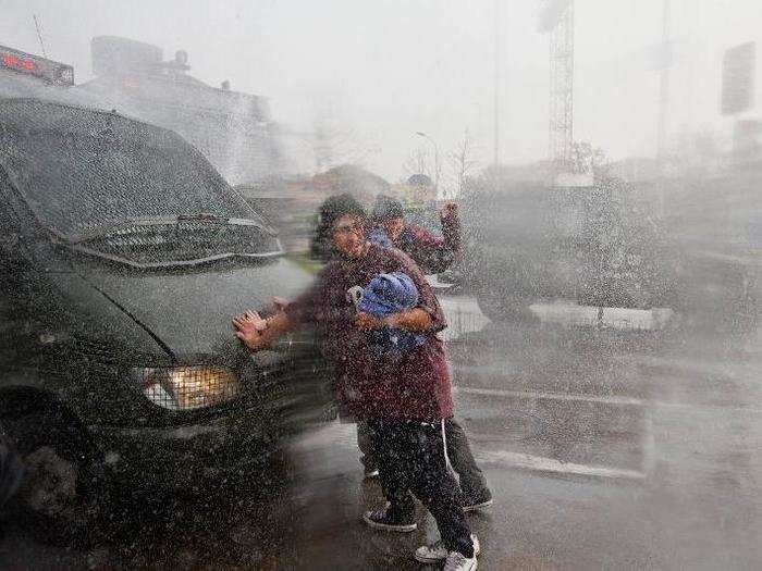 Demonstrators are sprayed with a police water cannon during clashes that erupted at the end of a march for education reform, in Santiago, Chile. Students are demonstrating to demand free access to school for all ages, including at the university level.