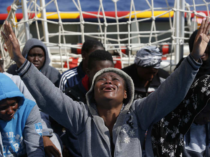 A tearful migrant prays on the Migrant Offshore Aid Station (MOAS) ship after being rescued off the coast of Libya.