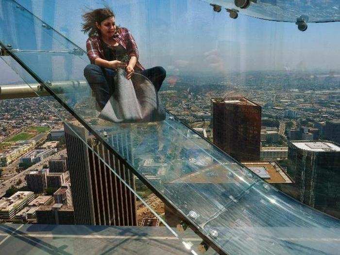 A member of the media rides down a glass slide during a media preview at the US Bank Tower building in downtown Los Angeles. Starting this weekend, thrill-seekers can begin taking the Skyslide, a 1,000 feet high slide, perched on the outside of the tallest skyscraper west of the Mississippi.