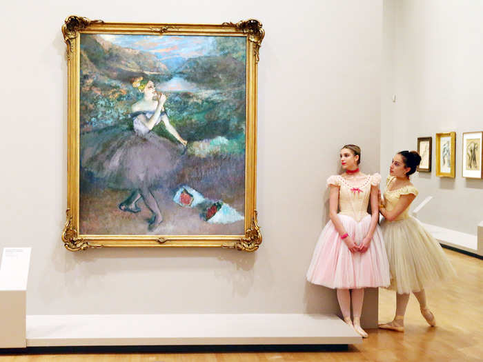 Artists of The Australian Ballet stand next to one of Edgar Degas