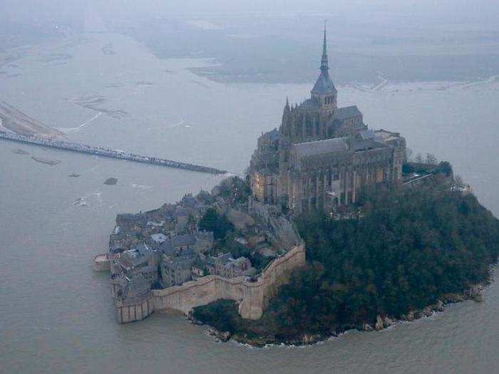 Mont-Saint-Michel in Normandy, France, is a medieval town perched on a small, rocky island in the middle of a muddy bay, crowned by a medieval abbey.