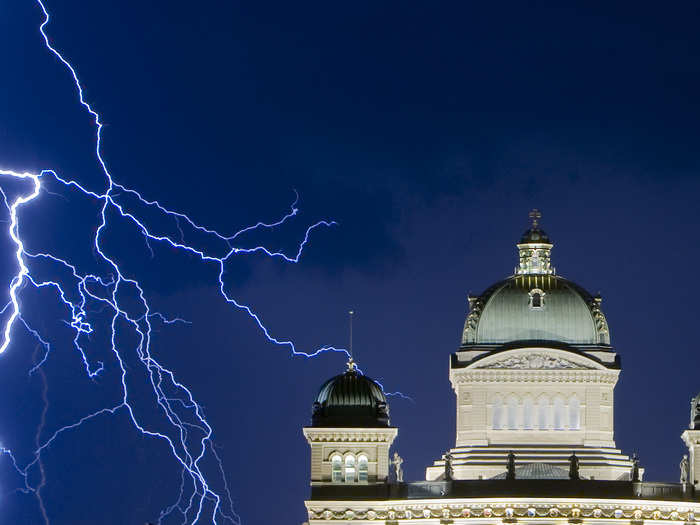 The finger-like bolts of lightning you can see here are the electrons traveling the path of least resistance to the ground. Here, the bolts reach for the Swiss Federal Palace in Bern, Switzerland on July 17, 2009.