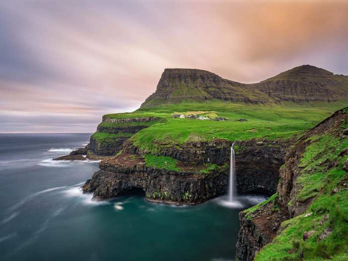 Journey to the edge of a cliff in the Faroe Islands to visit the remote village of Gásadalur and enjoy breathtaking views.