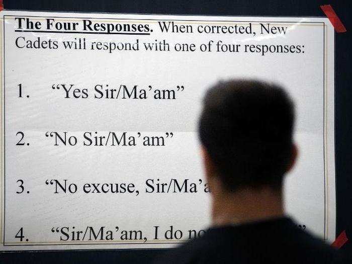 Signage instructs new cadets how to respond when corrected during in-processing procedures.