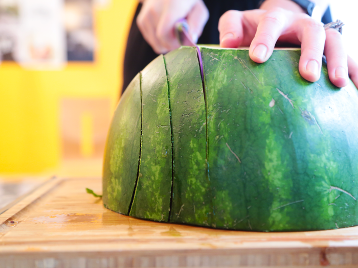 3. Place the watermelon face down on a cutting board. Cut vertically across the fruit in two-inch intervals.