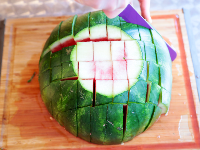 4. Turn the watermelon 90 degrees and repeat the previous step. Make sure to hold onto the sides while cutting so the slices don