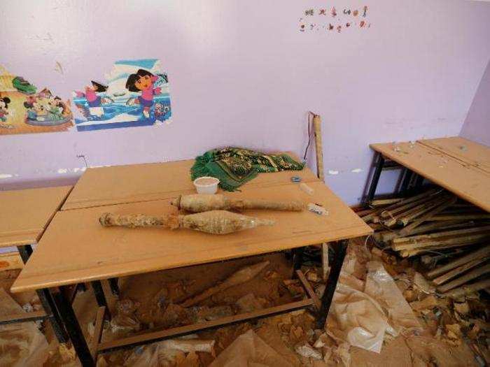 The militants left behind rocket-propelled grenades on a desk underneath a Dora The Explorer illustration in this school.