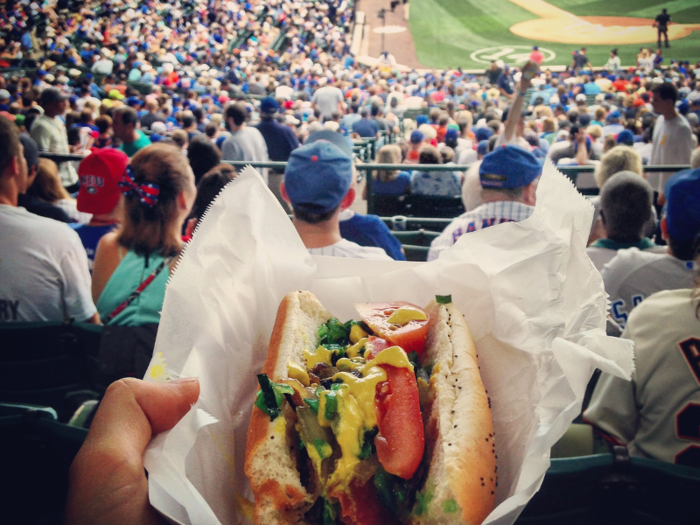 Cheer on your favorite team while enjoying a hot dog at a baseball game.