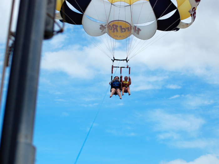 Soar high above the ocean while parasailing off the coast of Honolulu, Hawaii.