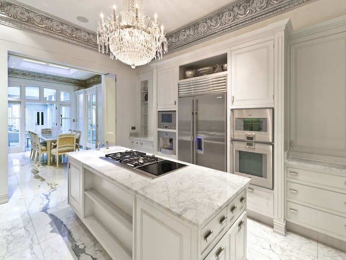 The kitchen and breakfast room have a modern, clean feel with marble countertops and sleek appliances, while the silver chandelier adds a touch of glamour.