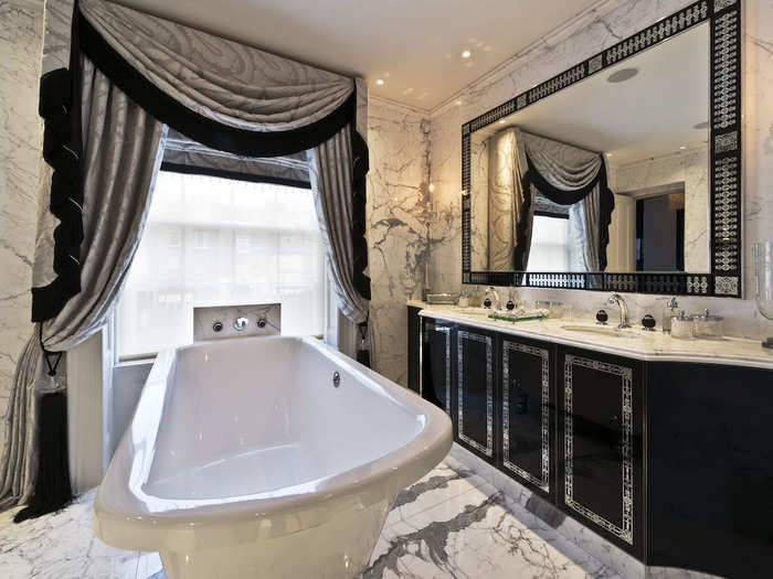 And this bathroom — one of six in total — has a free-standing bathtub with a view out of the window, and two sinks, as well as marble-covered floors, walls, and counters.