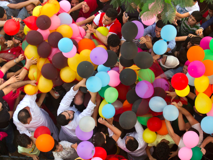 EGYPT: Celebrations often pour out into the streets. Muslims in Cairo waited to catch the hundreds of balloons distributed after Eid al-Fitr prayers.