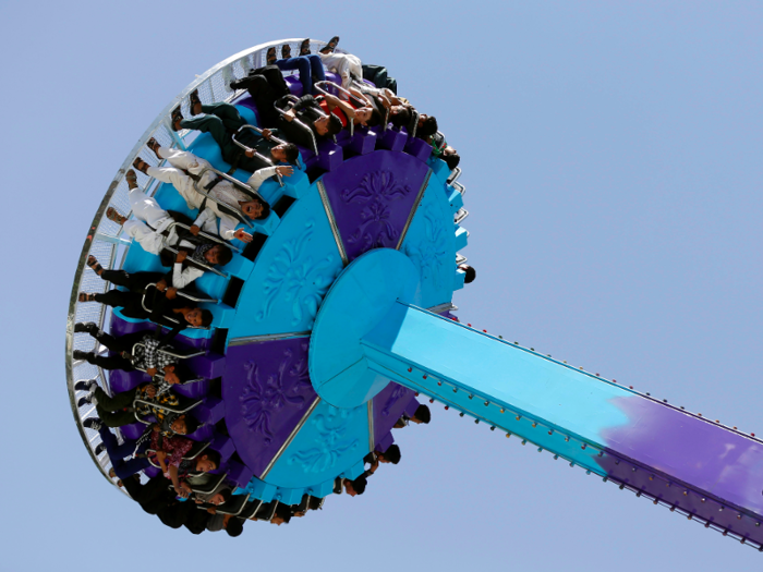 AFGHANISTAN: Amusements are set up for the younger revellers. These Afghani youths ride on a fairground attraction.