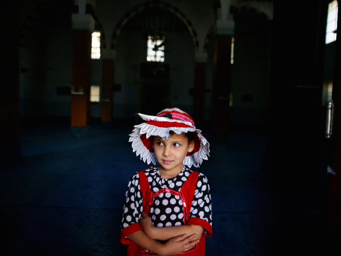 SYRIA: Tasneem, 4, stands at the door of a mosque after praying on the first day of the Muslim holiday.