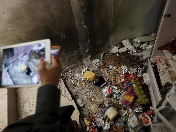 A journalist takes pictures of the scattered food items.