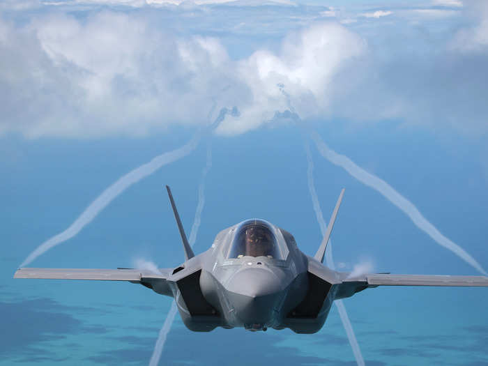 Contrails appear from the wings appear of an F-35B.