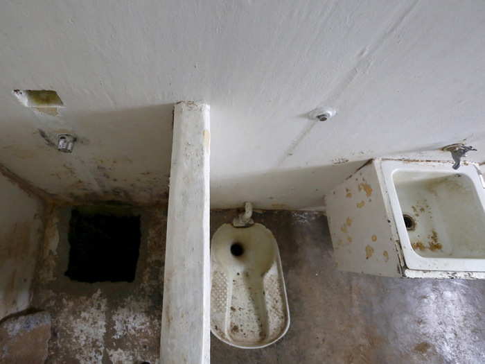 He crouched down behind a short wall that separated his shower from his toilet and sink.